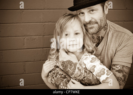 Padre tiene la sua figlia di cinque anni e guarda la fotocamera. Foto Stock