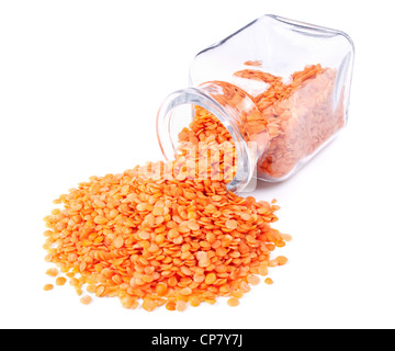 Red split lenticchie sparsi su uno sfondo bianco dal barattolo di vetro