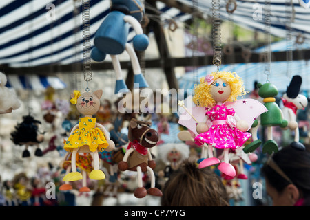 Appendere in legno giocattoli per bambini / bambole su un mercato in stallo. Oxford, Oxfordshire, Inghilterra Foto Stock