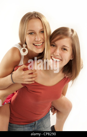Felice di due giovani donne, una porta le altre piggyback. Foto Stock