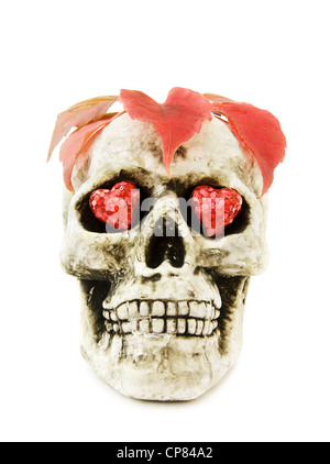 Celebrare Halloween con scary teschio umano decorata con cuori rossi e foglie. Isolato su sfondo bianco. Foto Stock