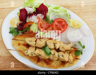 Pollo Tikka spiedini servita su in casa pane Naan flatbread con insalata Foto Stock