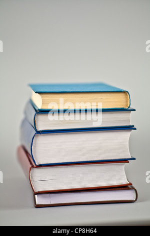 Pila di libri spessi su grigio Foto Stock