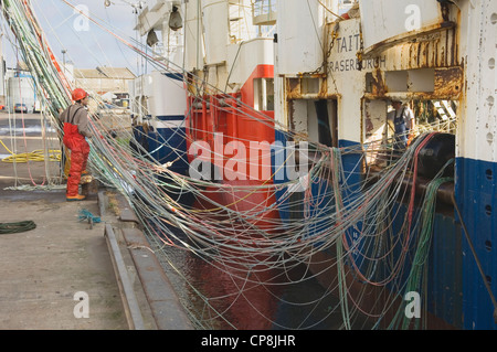 I pescatori operanti con reti di un grande mare profondo peschereccio nel porto di Fraserburgh, Aberdeenshire, Scozia. Foto Stock