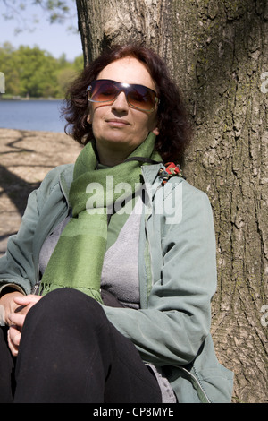 Donna di ottenere un po' di sole nel parco di Brooklyn, New York. Foto Stock