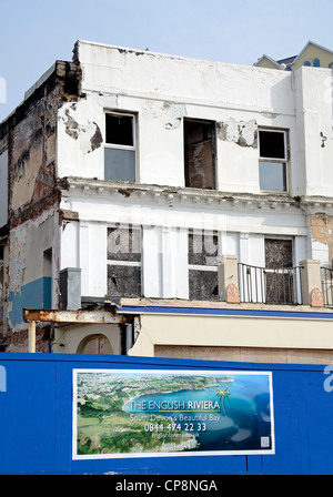 Una corsa verso il basso hotel dietro a cartelloni pubblicitari la riviera inglese a Torquay in devon, Regno Unito Foto Stock