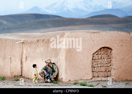 Un paracadutista noi con l'ottantaduesima Airborne Division della chat con un ragazzo afgano durante un'operazione di compensazione Aprile 28, 2012 in provincia di Ghazni, Afghanistan. Il soldato ha studiato i pashtun lingua prima della sua distribuzione a southern Ghazni. Foto Stock