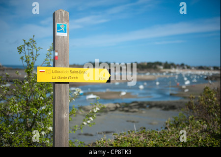 Marcatore per escursionisti sul sentiero costiero circumnavigando la baia e l'estuario del fiume Frémur vicino St-Briac in Bretagna Foto Stock