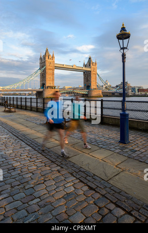 Due guide di scorrimento, Tower bridge con gli ultimi raggi dorati di luce al tramonto sul fiume Thames, London, Regno Unito Foto Stock