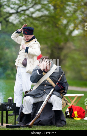 Francesi Napoleonici soldato stanco dopo la battaglia di prendere un periodo di riposo in costume in una guerra napoleonica rievocazione della società giorno Foto Stock