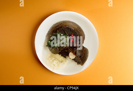 Pudding natalizio con crema, agrifoglio e fortunato sixpence Foto Stock