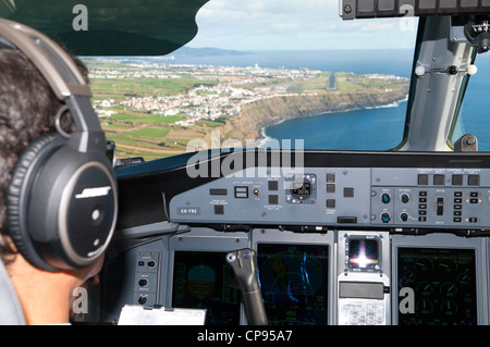 Pilota sul piano Dash Q400 cabina / cockpit preparazione a terra su una delle Azzorre Isola landing strip (Isola è São Miguel) Foto Stock