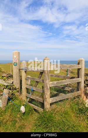 Baciare in legno cancello sulla isola di Anglesey sentiero costiero con Point Lynas al di là. Llaneilian Anglesey North Wales UK Foto Stock