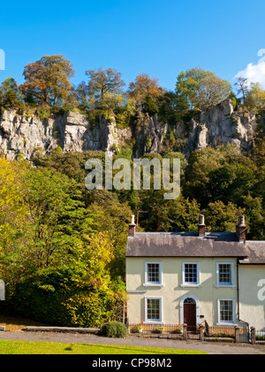 Scogliere calcaree popolare con arrampicatori in Matlock Bath village Derbyshire Peak District Inghilterra UK con cottage nella parte anteriore Foto Stock