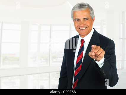 Persone di mezza età imprenditore in un ufficio moderno impostazione puntando alla fotocamera. Formato orizzontale. Foto Stock