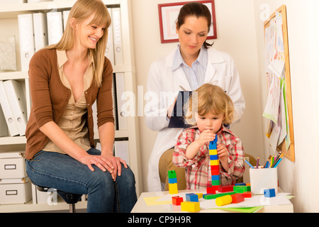 Visita al pediatra bambino ragazza gioca a ufficio medico Foto Stock