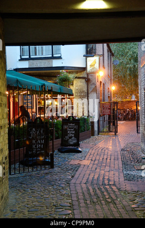 Sera illuminata arch a piedi attraverso il vecchio edificio in pietra pub Foto Stock