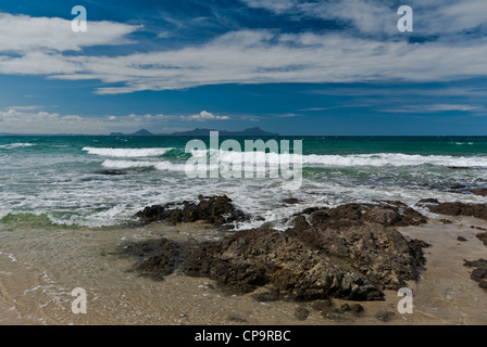 Nuova Zelanda Isola del nord Waipu Cove Breme Bay rock e surf con isole vulcaniche di distanza Foto Stock