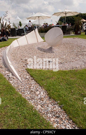 Vista parziale di 'Wave Dance' mostra giardino (scultura & ciottoli bianchi) con persone al Terrace cafe al di là - RHS Flower Show, Tatton Park, Inghilterra, Regno Unito. Foto Stock