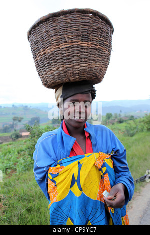 Donna ruandese che trasportano un cestello sul suo capo nella provincia occidentale del Ruanda. Foto Stock