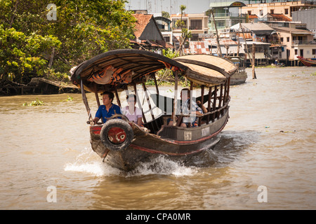 I turisti che viaggiano su un piccolo traghetto, Cai Be, il fiume Mekong Delta, Vietnam Foto Stock
