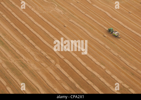 Vista aerea di un trattore in un campo di grano dopo il raccolto Foto Stock