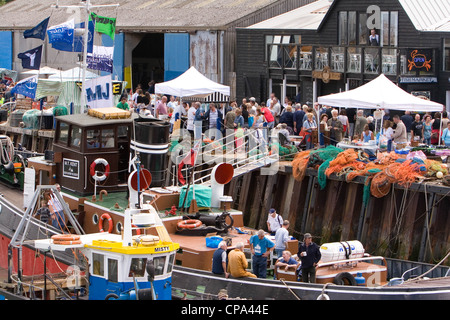 Barche, reti e le bancarelle del mercato, Whistable Harbour, Kent, England, Regno Unito Foto Stock