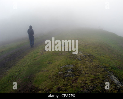 Walker in heavy mist, Malvern Hills, Worcestershire, England, Regno Unito Foto Stock