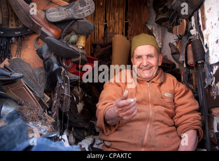 Cobbler marocchino siede alla porta di un negozio all'interno della Medina Marrakech marocco Foto Stock