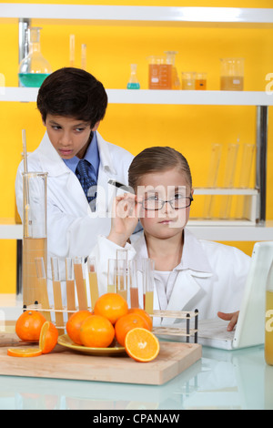 I bambini facendo esperimenti di chimica con succo di arancia Foto Stock