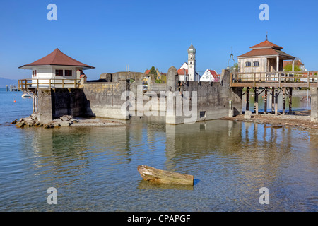 Il vecchio bagno case, il lago di Costanza, Wasserburg, Baviera, Germania, sullo sfondo la chiesa parrocchiale di San Giorgio Foto Stock
