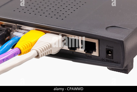 Macro shot di tappi su cavi CAT5e di molti colori isolati contro uno sfondo bianco inserito nel router Foto Stock
