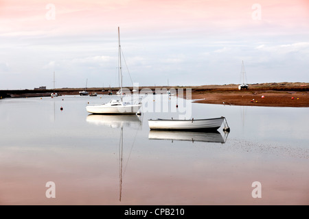 Barche di sedersi con garbo idolo come la marea comincia a rifluire in a 'Blakeney porto' di Norfolk, Regno Unito Foto Stock