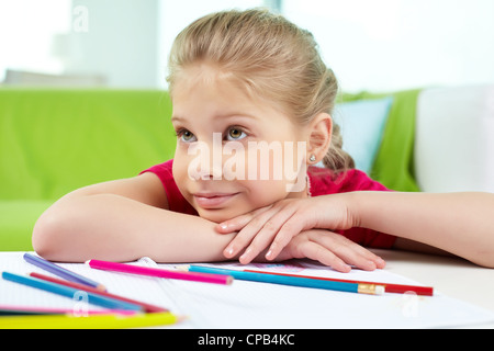Ritratto di una bella bambina che dipinge una foto in uno studio o