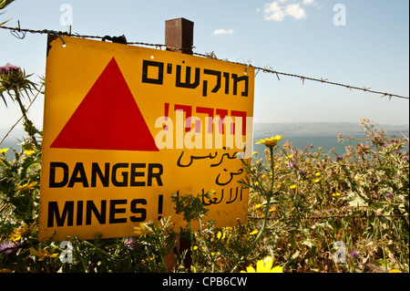 Un segno a leggere 'Drabbia mine!' appeso ad un filo spinato israeliano occupato Golan. Foto Stock