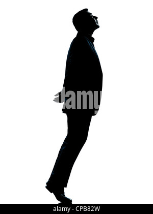 Un business caucasica silhouette uomo punta di piedi permanente alla ricerca fino a lunghezza piena in studio isolato su sfondo bianco Foto Stock