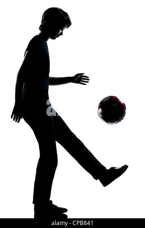 Un caucasian adolescente silhouette ragazza ragazzo juggling soccer football per tutta la lunghezza in studio di ritagliare isolati su sfondo bianco Foto Stock