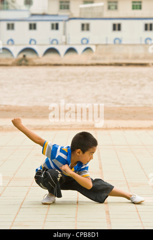 Un giovane ragazzo cinese pratica arti marziali. Foto Stock