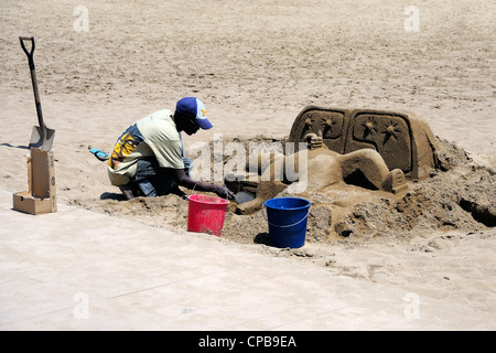 Un cane la scultura di sabbia a Platja de Sant Sebastià spiaggia di La Barceloneta, Barcelona, Spagna. Foto Stock