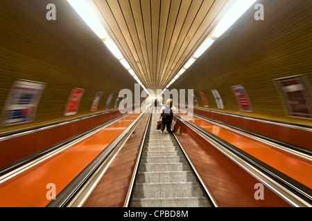 Persone che si muovono su delle scale mobili in metropolitana Foto Stock