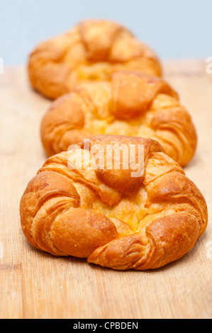 Tre freschi di forno croissant francesi brioche sul pannello di legno Foto Stock