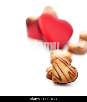 A forma di cuore i cookie di crema sul cuore rosso scatola di metallo Foto Stock