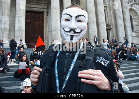 Occupare, Londra UK. Anti capitalismo dimostrazione, parte di una giornata di azione globale. Protester in anonimo maschera di Guy Fawkes indossando "polizia" uniforme . Foto Stock