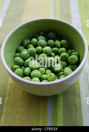 Sgusciate maturi freschi dolci verdi piselli in un vaso di ceramica Foto Stock