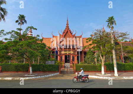 Vista orizzontale di un ciclomotore guida superato l'ingresso anteriore del Museo Nazionale della Cambogia a Phnom Penh. Foto Stock