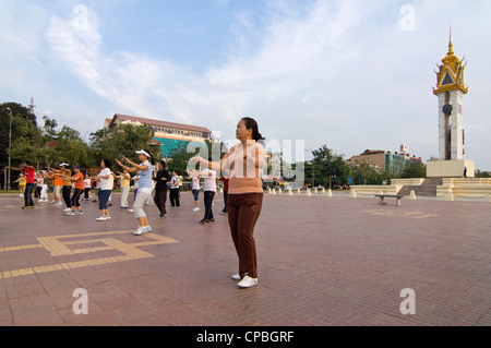 In orizzontale ampia angolazione del Cambodia-Vietnam amicizia Monumento a Phnom Penh con la popolazione locale facendo un esercizio di classe. Foto Stock