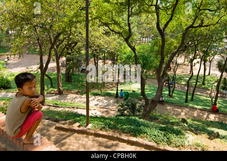 Vista orizzontale di un ragazzo cambogiano nei giardini al Wat Phnom, aka tempio di montagna o mountain Pagoda in Phnom Penh Cambogia Foto Stock