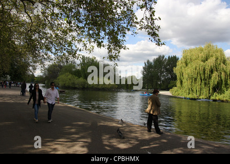 Persone alimentazione di uccelli sul lago in barca a Regents Park a Londra Foto Stock