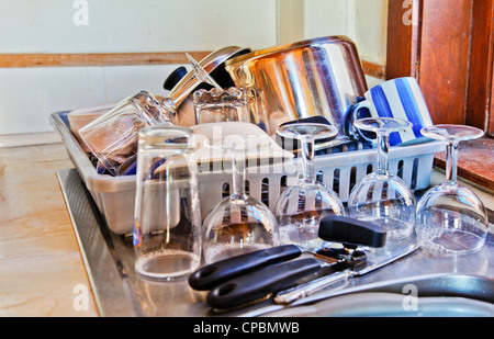 Scheda di drenaggio e cucina lavandino ad angolo in un cottage impilati con lavato fino utensili da cucina Foto Stock