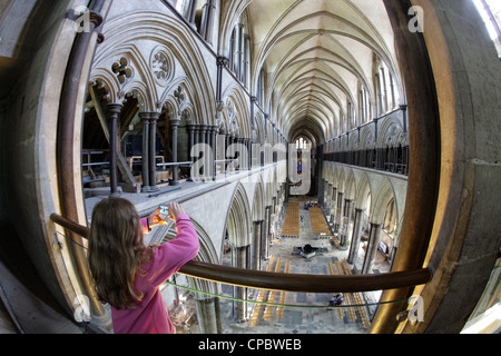 Una giovane ragazza prende una fotografia della Cattedrale di Salisbury navata da una galleria sul fronte Ovest. Foto Stock